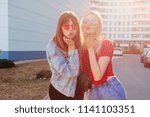 Small photo of Glad ladies send cuss to camera, posing over modern street background. Friendship concept.