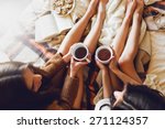 Soft photo of two  sisters  on the bed with old books and cup of tea in hands wearing cozy sweater , top view point. Two best friends enjoying morning.
