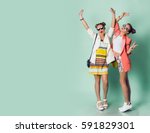Full height image  of two happy cheeky girls  , best friends having fun , laughing on blue background. . Wearing stylish  casual jackets, striped pop dress. Space for text. 