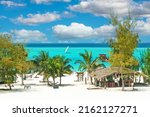 Small photo of Beautiful tranquil empty bright white paradise sand beach, sun beds, palm trees, bamboo hut bar, turquoise water - Paje, Zanzibar