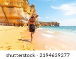 A woman on beach vacation at Praia da Coelha, Algarve, Albufeira. Portugal