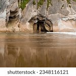 Small photo of Cave in Itzurun beach cliffs. Reflexion on water