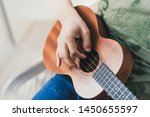 Small photo of ukulele game. a man playing a little guitar. the performer writes the music on the ukulele at home.