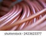 Small photo of Close-up of new copper wire wound into a coil. Close-up of coils of copper wire. Copper wire randomly wound into a coil. A detailed shot of copper wires with selective focus