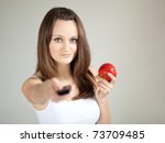 Young woman with remote control and apple