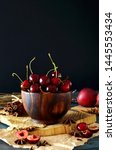 Small photo of Rustic Composition of Cherries in wooden bowl on blocks of wood and crat paper. ingedient for cherry desert. Summer dieting.