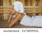 Woman lying on a bench in a sauna
