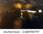Silhouette of a young couple in the sunset light kissing in a car