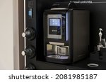 Small photo of Russia, Moscow - November 21, 2021: Table top vending coffee machine Necta Krea stands on black wooden furniture in automated self-service cafe. Illustrative editorial. New vending solution theme.