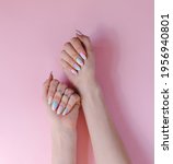 Small photo of trendy youth manicure in unicorn color. Design with blue and pink stains. Gel polish coating. Hands with varnished nails. Copy space top view. Pstel gentle tones. Fresh summer mood