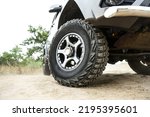 Small photo of SUV wheel close up is on nature background in summer. off-road car tyre close up outdoor. mud tire close up is on off road car.