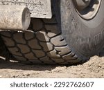 Small photo of A close-up of a grime-laden tire entrenched in soil