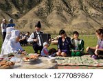 Small photo of Saty townsfolk some in traditional clothes at a picnic by the Chilik river Kungey Alatau mountains Saty, Kazakhstan - September 7, 2016