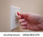 Small photo of Electrical outlet with electricity safety cover to prevent child electrocution. Baby proofing household power sockets with plastic plug inserts.