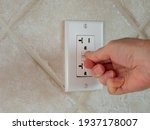 Small photo of Resetting GFCI ground fault interrupter electricity receptacle and wall plate. Residential electric plug with GFI reset button.