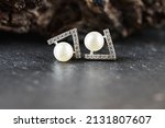 Small photo of A beautiful Pearl Ear studs. Close-up of white pearl earrings.
