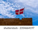 Small photo of Red rectangular flag with the white latin cross. The State flag of the Sovereign Order of Malta.