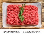 Fresh Raw mince beef, ground meat on butcher paper. wooden background. Top view