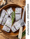 Small photo of Cut Raw grenadier macrurus white fish without head in a wooden plate. Wooden background. Top view
