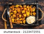 Small photo of Patatas bravas traditional Spanish potatoes snack tapas. Dark wooden background. Top view