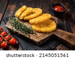 Small photo of Hash brown potato, Potato Patties on a wooden board with ketchup. Wooden background. Top view.