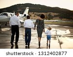 Family walking towards a private jet holding hands
