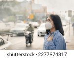 Small photo of Asian woman wearing the N95 Respiratory Protection Mask against PM2.5 air pollution and headache Suffocate. City air pollution concept
