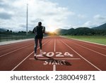 Small photo of Happy New Year 2024 symbolizes the start of the new year. Woman preparing to run on the athletics track is engraved with the year 2024. start challenge goal of planning health and business to success