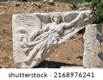 Small photo of Stone carving of goddess Nike, Ephesus or Efes, Kusadasi, Turkey. Marble relief of winged Nike Goddess of Victory Ephesus Turkey. Carved marble statue. Sculpture of goddess Nike in archaeological site