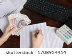 Small photo of Hands holding Russian rubles at the Desk in the office. Russian Russian cashier Manager at the workplace in a Russian Bank.Issuing salaries, pensions and unemployment benefits in Russia