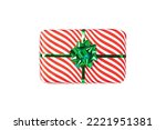 Wrapped red gift box with shiny green ribbon bow, object isolated on white background. A holiday striped wrapper, top view. Christmas present, new year decoration.