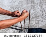 Small photo of male hands unbend reinforcement which sticks out of concrete