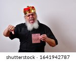Small photo of A really fierce and sadistic employer fires a hapless employee. Example of corporate greed. Mature jerk with a golden crown and black guayabera shirt and long white beard.