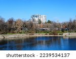 Small photo of Bucharest, Romania, 7 January 2021: Landscape with white cloudy sky and the Herastrau Lake (Lacul Herastrau) in King Michael I Park (Parcul Regele Mihai) in a sunny and cold winter day