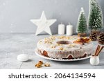 Homemade Orange cake on the white background. Traditional Christmas cake decorated with white sugar icing with candied fruits and dried fruits. Holiday background.