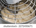 Small photo of industrial dough mixer kneads the dough. Raw dough in a industrial bakery dough mixer, food concept. close-up