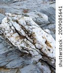 Small photo of A vertical shot of raw marble rock texture on a geological flinch in Sopelana, Spain