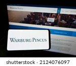 Small photo of STUTTGART, GERMANY - Jan 08, 2022: Person holding mobile phone with logo of American private equity company Warburg Pincus LLC on screen in front of webpage Focus on phone display