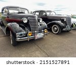 Small photo of MO, ARGENTINA - Mar 27, 2022: old black Chevrolet Chevy Master Deluxe coupe with rumble seat 1938 by GM Sedan in the background CADEAA 2022 at MNA classic car show