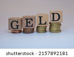 Small photo of A closeup shot of four group of coins with four cubes on them has letters GELD on isolated background