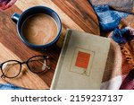 Small photo of FORSYTH, UNITED STATES - Aug 19, 2019: A top view of reading glasses and book with blanket and coffee