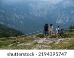 Small photo of BOHINJ, SLOVENIA - Aug 13, 2022: A closeup of people looking over a wooden fence at a valley in the Vogel top of the Alp mountains