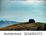 A small house standing on a hill with the background of mountain ranges far away, Zlatibor, Serbia