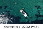 Small photo of A drone shot of a boat in the tranquil sea cliff at Agia Eleni Rocky Beach in Greece