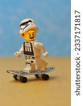 Small photo of GREENVILLE, US - Jun 15, 2022: A smiling lego figurine with a stormtrooper helmet riding on a skateboard