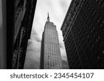 A low angle shot of the Empire State building of New York City, USA in grayscale