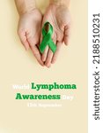Small photo of Adult hands holds green ribbon on beige background. World lymphoma awareness day. September 15. Liver, Gallbladders bile duct, kidney Cancer and Lymphoma Awareness month. Vertically photo