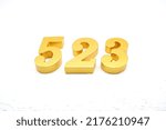 Small photo of Number 523 is made of gold painted teak, 1 cm thick, laid on a white painted aerated brick floor, visualized in 3D.