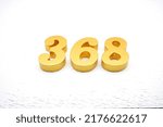 Small photo of Number 368 is made of gold painted teak, 1 cm thick, laid on a white painted aerated brick floor, visualized in 3D.