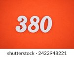 Small photo of Orange felt is the background. The numbers 380 are made from white painted wood.